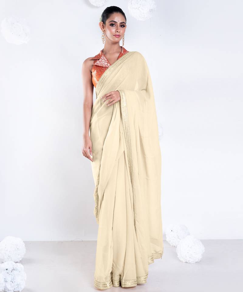 Beige color Georgette saree with golden embroidered border
