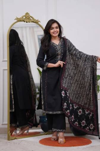 black cotton kurta, pants, and a printed dupatta set.