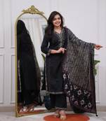 black cotton kurta, pants, and a printed dupatta set.