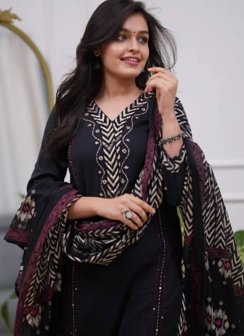 black cotton kurta, pants, and a printed dupatta set.