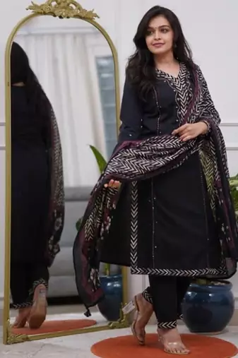black cotton kurta, pants, and a printed dupatta set.