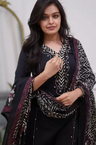 black cotton kurta, pants, and a printed dupatta set.