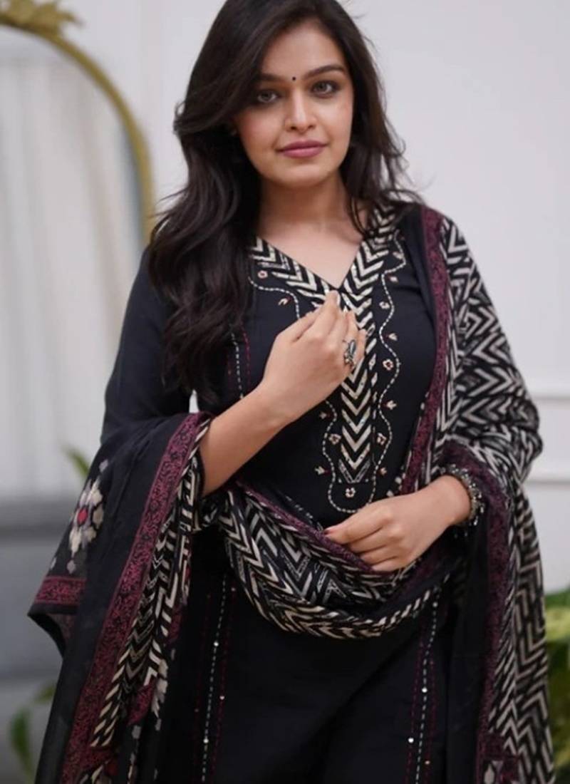 black cotton kurta, pants, and a printed dupatta set.