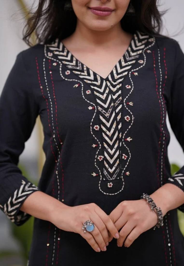 black cotton kurta, pants, and a printed dupatta set.