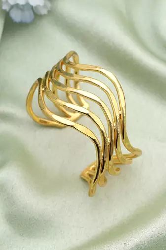 Gold color bracelet created with artistic detailing to enhance festive looks with radiant appeal