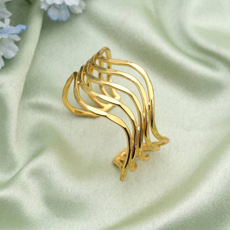 Gold color bracelet created with artistic detailing to enhance festive looks with radiant appeal