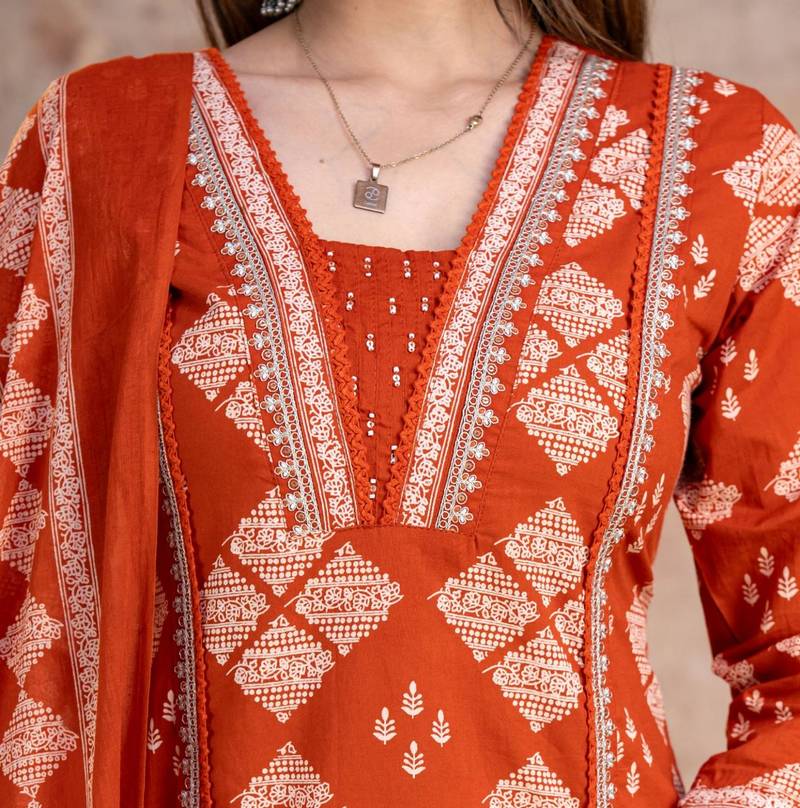 Beautiful jaipuri a rust orange cotton kurta, pant, and dupatta set with floral applique designs and orange piping.