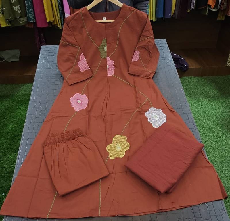 Beautiful jaipuri a rust orange cotton kurta, pant, and dupatta set with floral applique designs and orange piping.