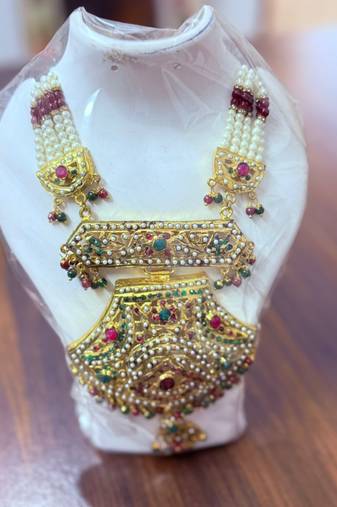 Golden necklace with green stone work  and kundan work