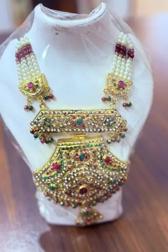 Golden necklace with green stone work  and kundan work