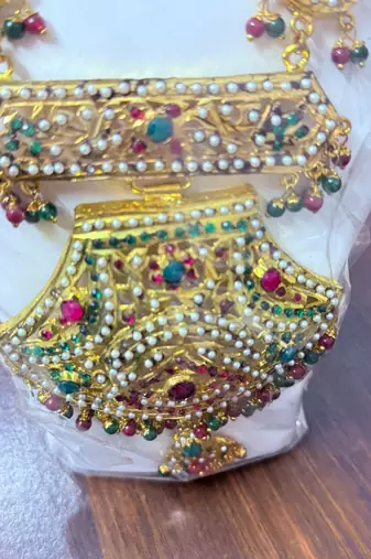 Golden necklace with green stone work  and kundan work