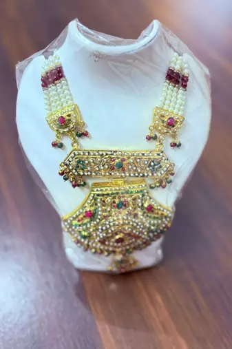 Golden necklace with green stone work  and kundan work