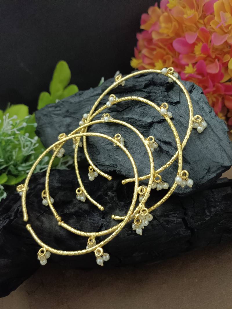Set of 4 gold-plated adjustable bangles with pearl drop charms