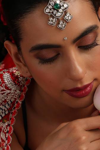 Gold plated kundan green stone mang tikka