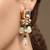 Gold plated kundan green stones dangler earrings