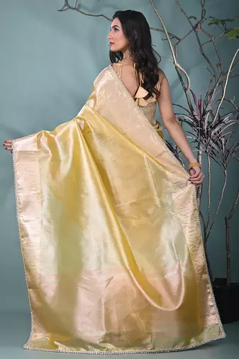 yellow tissue saree with intricate silver zari border