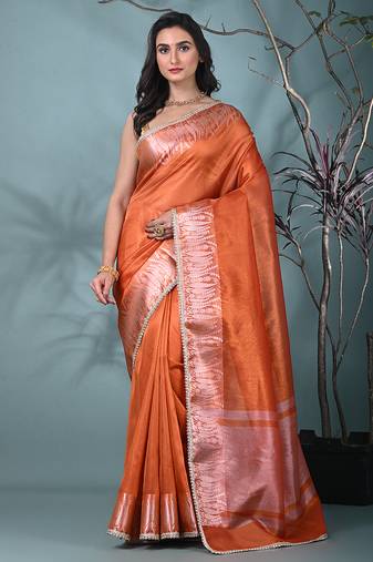 orange tissue saree with intricate silver zari border