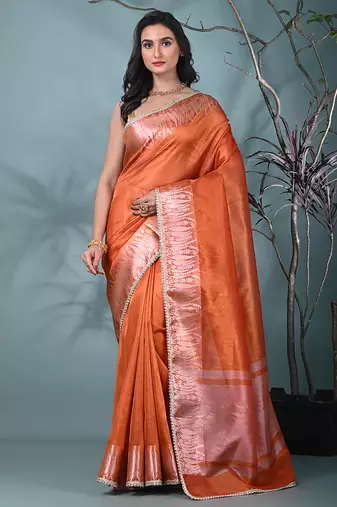 orange tissue saree with intricate silver zari border