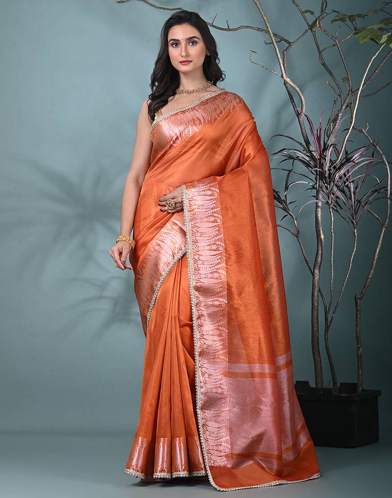 orange tissue saree with intricate silver zari border