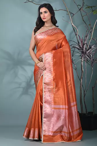 orange tissue saree with intricate silver zari border