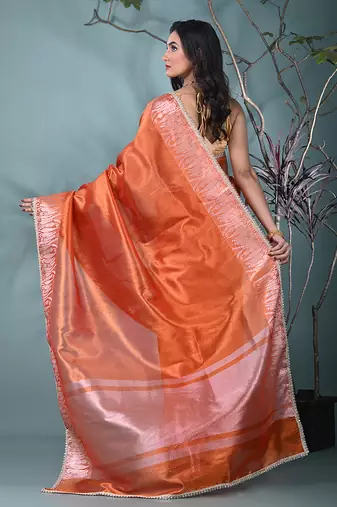 orange tissue saree with intricate silver zari border