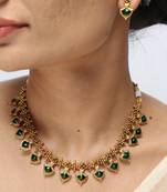 gold plated necklace set with emerald leaf motifs