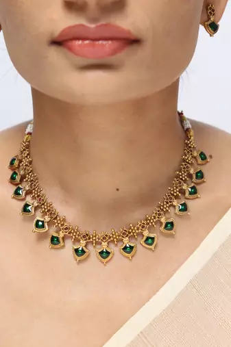 gold plated necklace set with emerald leaf motifs
