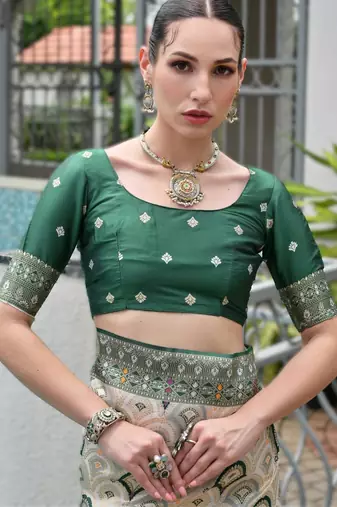 Green banarasi silk blend saree in ajrakh and patola weaving with zari pallu