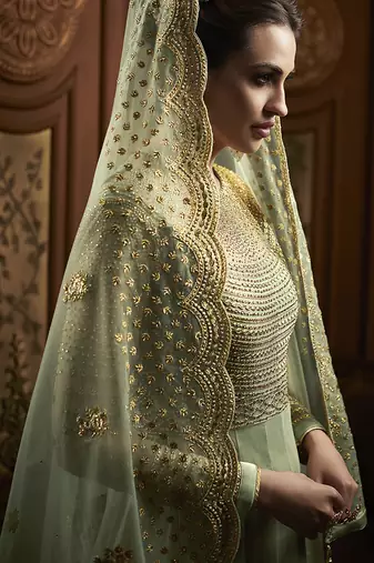 Soft net anarkali party wear salwar kameez in green color with embroidery and crystal stone work