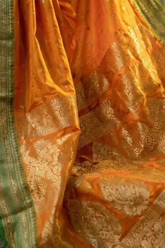 The sunset glow: vibrant orange soft silk blend saree with contrast green zari border
