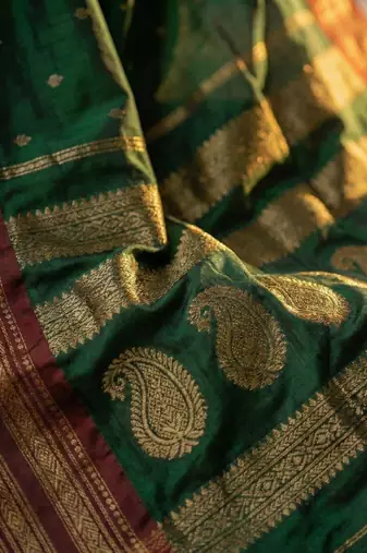 The emerald empress: dark green soft silk blend saree with rich crimson red zari border