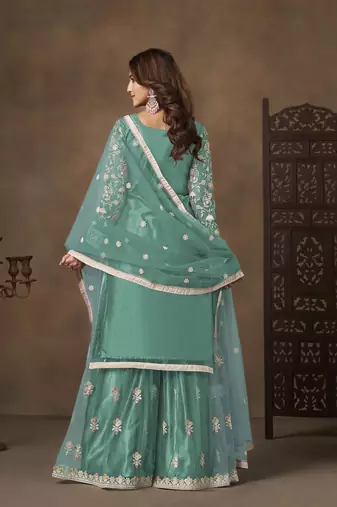 Turquoise net heavy thread embroidery with sequins work palazzo suit