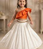 Orange one-shoulder top with ivory skirt