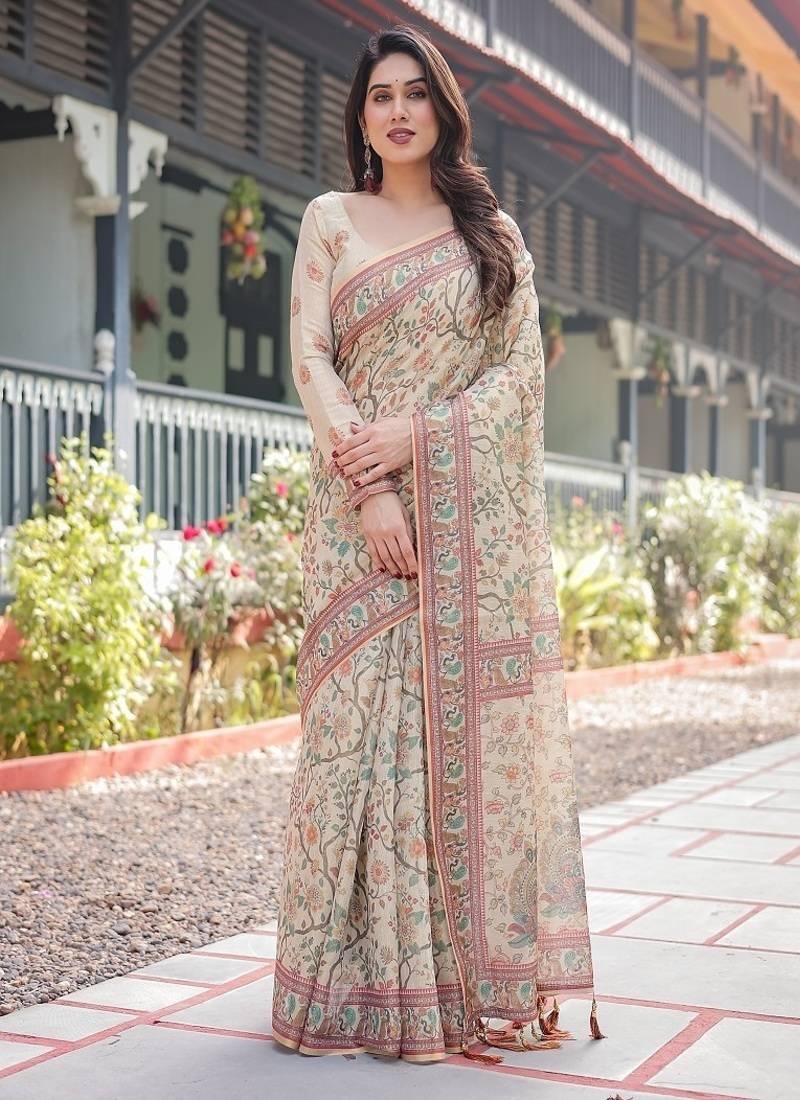 Ivory handloom cotton-linen saree with floral and peacock motifs, zari highlights, and tassel finish