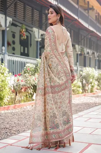 Ivory handloom cotton-linen saree with floral and peacock motifs, zari highlights, and tassel finish