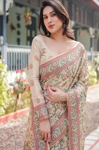 Ivory handloom cotton-linen saree with floral and peacock motifs, zari highlights, and tassel finish