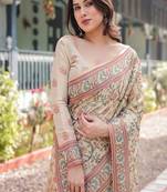 Ivory handloom cotton-linen saree with floral and peacock motifs, zari highlights, and tassel finish