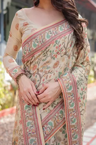 Ivory handloom cotton-linen saree with floral and peacock motifs, zari highlights, and tassel finish