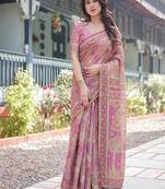 Regal pink handloom cotton-linen saree with floral motifs, golden zari highlights, and tassel detailing