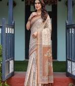Ivory handloom cotton-linen saree with floral and peacock motifs, zari highlights, and tassel finish