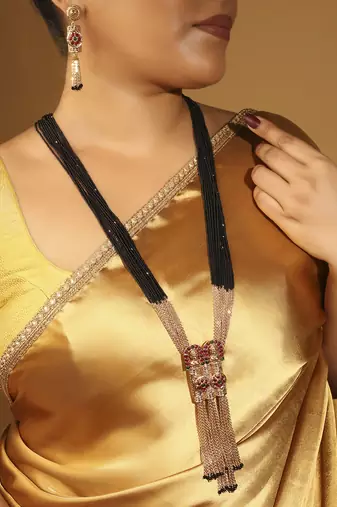 gold tone temple style long mangalsutra set with flower motifs