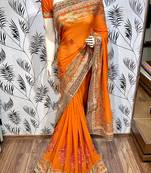 Pure georgette party wear saree in orange with embroidery work & crystal stone work