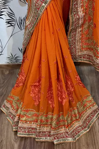 Pure georgette party wear saree in orange with embroidery work & crystal stone work