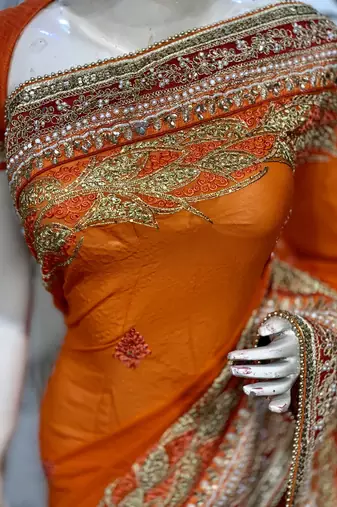 Pure georgette party wear saree in orange with embroidery work & crystal stone work