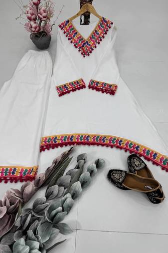 Modern white kaftan-style tunic with vibrant geometric border and pom-poms