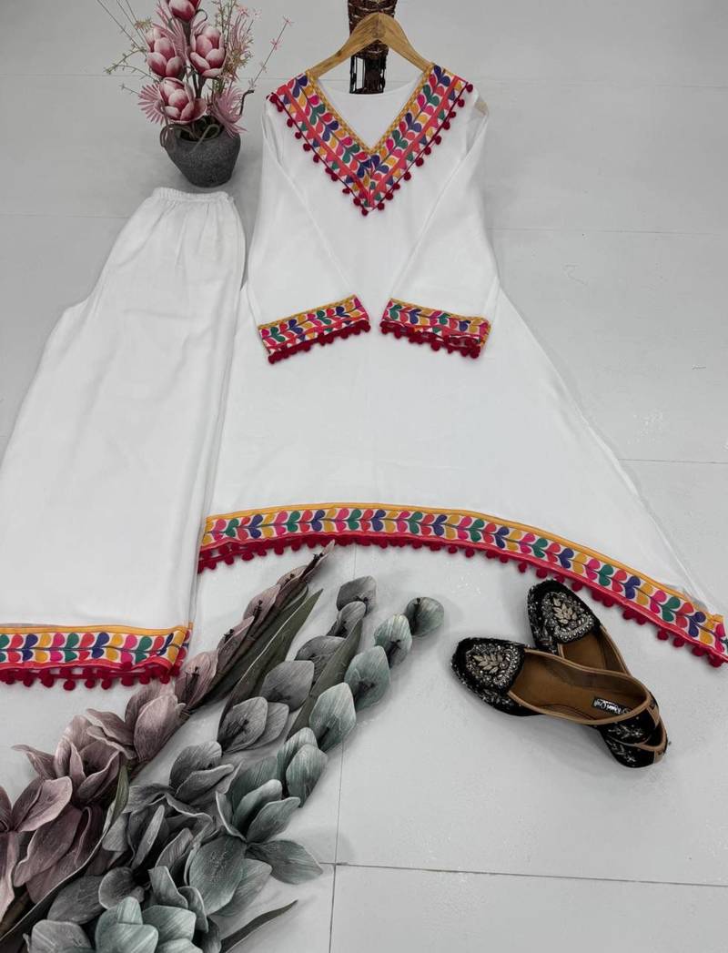 Modern white kaftan-style tunic with vibrant geometric border and pom-poms