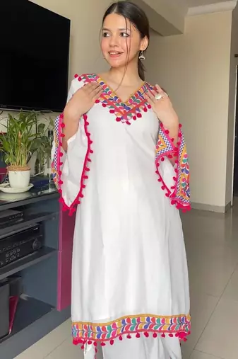 Modern white kaftan-style tunic with vibrant geometric border and pom-poms