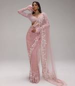 Pink embroidered net saree with feather-trimmed blouse and tassel detail