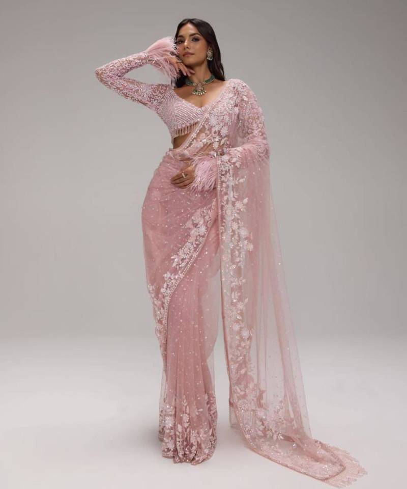 Pink embroidered net saree with feather-trimmed blouse and tassel detail