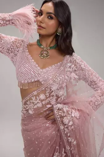 Pink embroidered net saree with feather-trimmed blouse and tassel detail